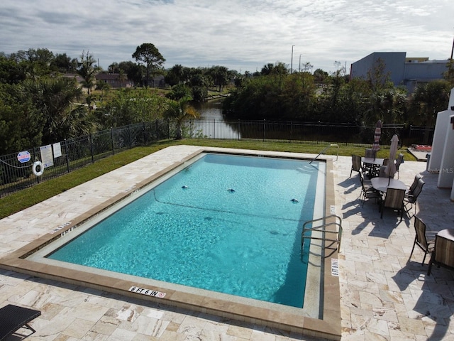 view of pool featuring a patio area and a water view