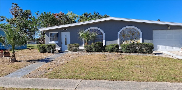 ranch-style home featuring a garage and a front lawn