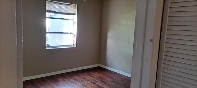 unfurnished room with a wealth of natural light and dark wood-type flooring