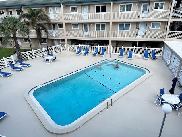 view of pool with a patio area and fence