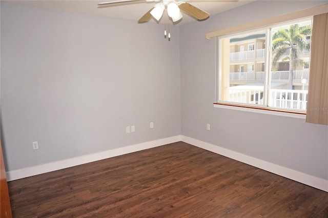 spare room with ceiling fan, baseboards, and dark wood-style flooring