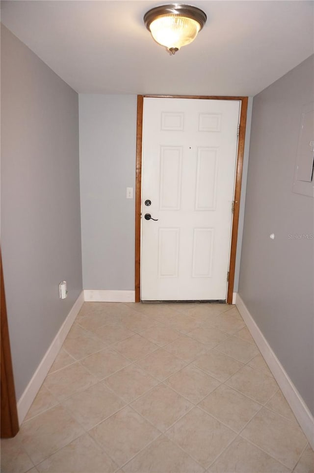 entryway with light tile patterned flooring and baseboards