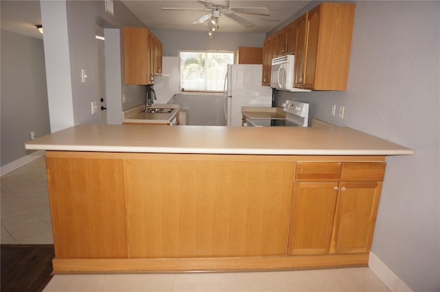 kitchen featuring ceiling fan, a peninsula, white appliances, a sink, and light countertops