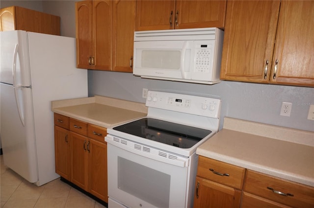 kitchen with light countertops, white appliances, light tile patterned flooring, and brown cabinets