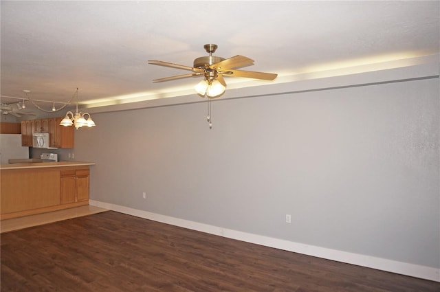 kitchen with white appliances, baseboards, wood finished floors, light countertops, and ceiling fan with notable chandelier