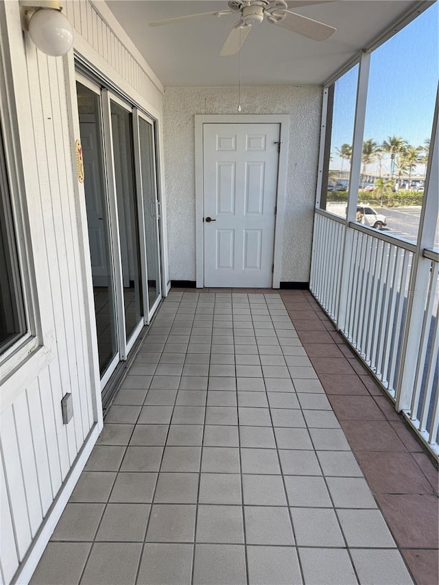 unfurnished sunroom featuring a ceiling fan