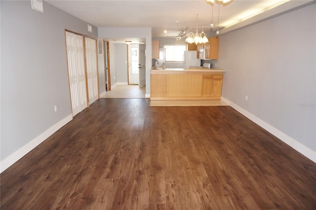 kitchen with light countertops, white appliances, dark wood-style flooring, and baseboards