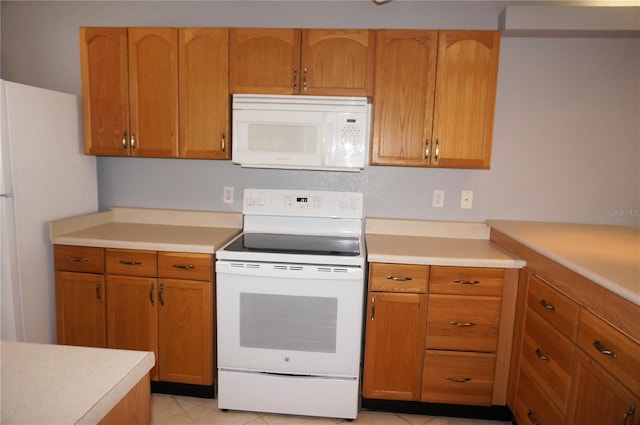 kitchen featuring white appliances, light tile patterned floors, and light countertops