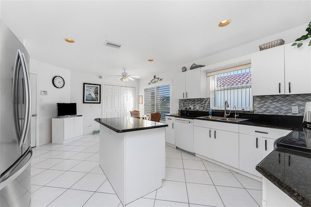 kitchen with stainless steel fridge, white dishwasher, white cabinetry, and sink