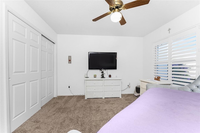 carpeted bedroom with ceiling fan and a closet