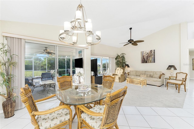 dining area with ceiling fan with notable chandelier, lofted ceiling, and light tile patterned flooring