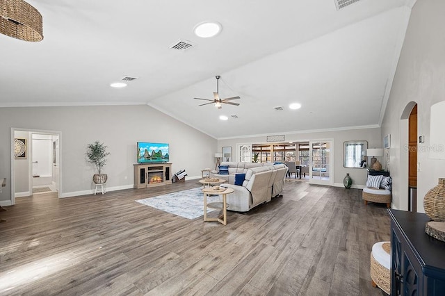 living room featuring wood-type flooring, ornamental molding, ceiling fan, and lofted ceiling