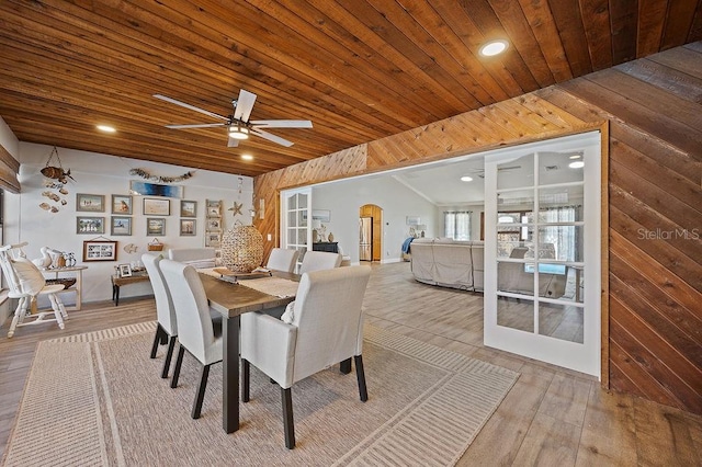 dining area with ceiling fan, wood-type flooring, wooden walls, and wooden ceiling