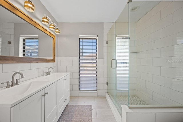 bathroom featuring tile patterned floors, vanity, an enclosed shower, and tile walls