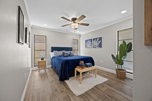 bedroom with ceiling fan, hardwood / wood-style floors, and ornamental molding