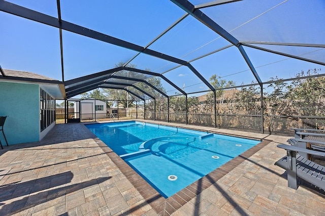 view of swimming pool with glass enclosure, a patio area, and a shed