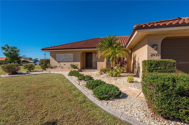 mediterranean / spanish-style home with a front lawn and a garage