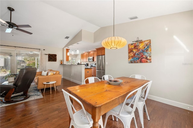 dining room with ceiling fan, dark hardwood / wood-style flooring, and vaulted ceiling