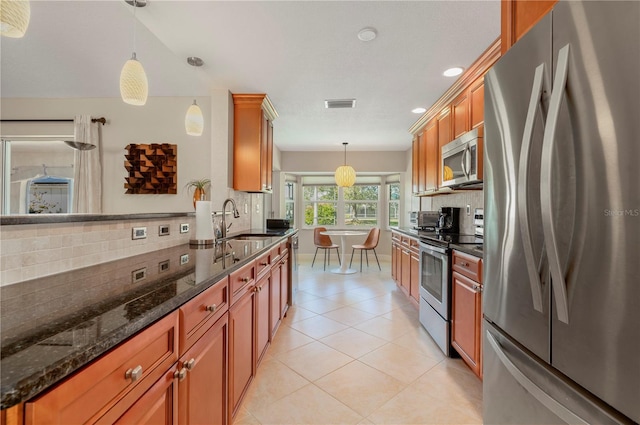 kitchen featuring tasteful backsplash, pendant lighting, and appliances with stainless steel finishes