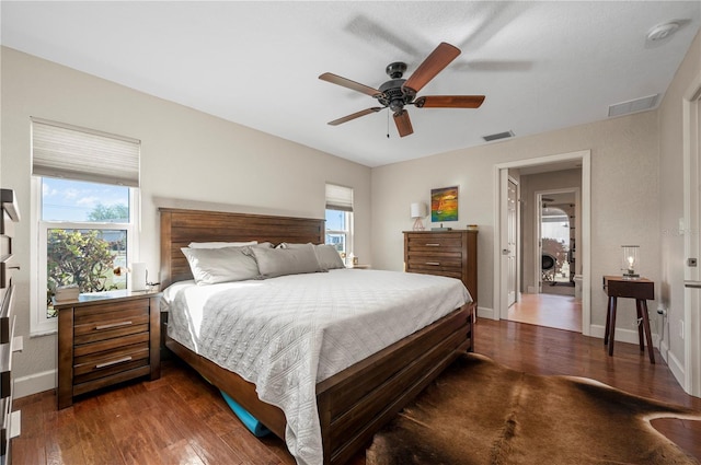 bedroom featuring multiple windows, ceiling fan, and dark wood-type flooring