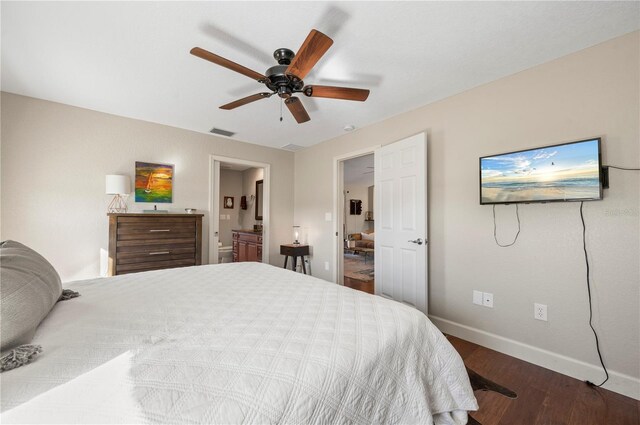 bedroom with dark hardwood / wood-style flooring, ceiling fan, and connected bathroom