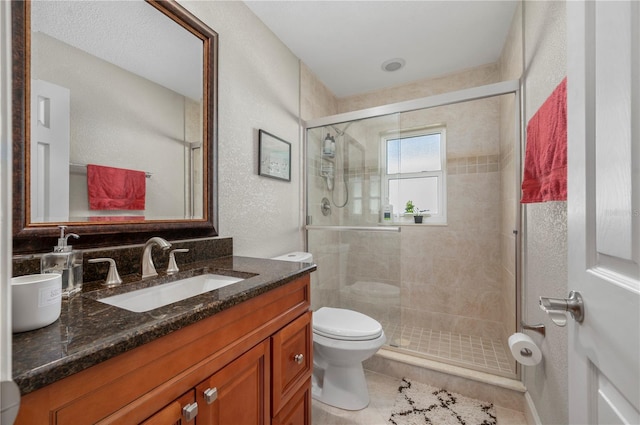 bathroom featuring tile patterned floors, vanity, toilet, and an enclosed shower