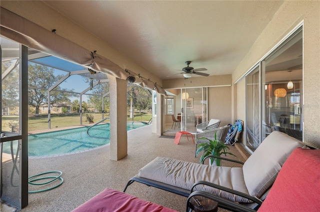 view of patio with glass enclosure and ceiling fan