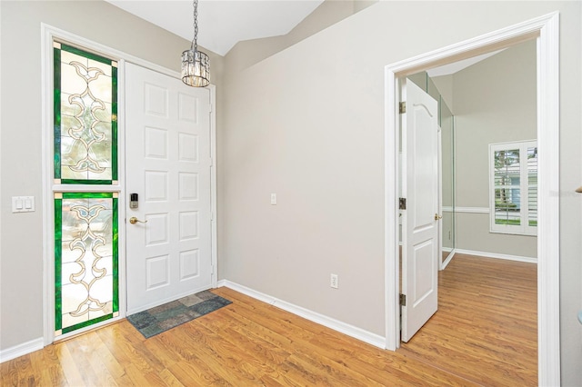 entrance foyer featuring vaulted ceiling and light hardwood / wood-style flooring