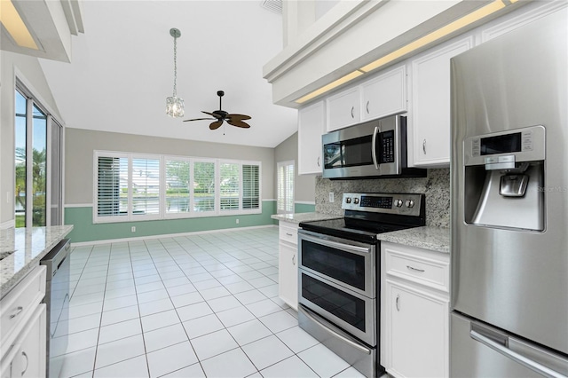 kitchen featuring white cabinets, light stone countertops, tasteful backsplash, light tile patterned flooring, and stainless steel appliances