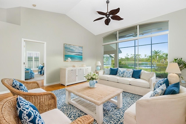 living room featuring hardwood / wood-style flooring, ceiling fan, and high vaulted ceiling