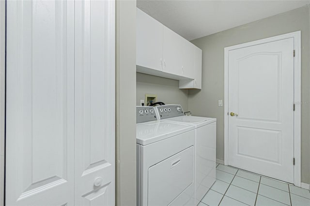 washroom featuring cabinets, light tile patterned floors, and washer and clothes dryer