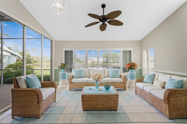 sunroom featuring ceiling fan with notable chandelier, lofted ceiling, and a healthy amount of sunlight