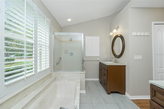 bathroom with vanity, separate shower and tub, plenty of natural light, and lofted ceiling