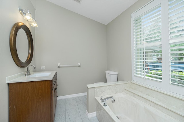 bathroom with vanity, a bathtub, and a healthy amount of sunlight