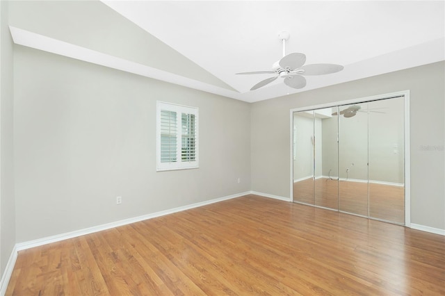 unfurnished bedroom featuring ceiling fan, a closet, lofted ceiling, and hardwood / wood-style flooring