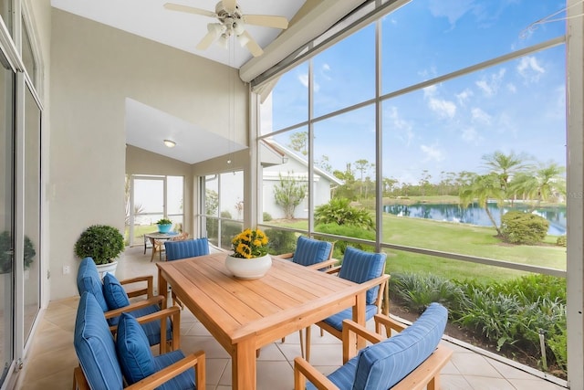 sunroom / solarium with ceiling fan and a water view