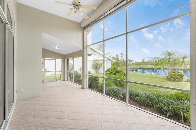 unfurnished sunroom with ceiling fan, a healthy amount of sunlight, a water view, and lofted ceiling