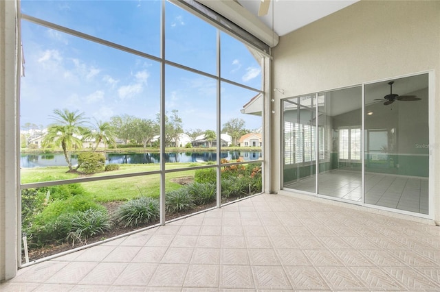 unfurnished sunroom featuring a water view, ceiling fan, and lofted ceiling