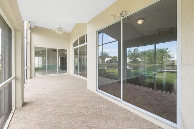 unfurnished sunroom with ceiling fan and lofted ceiling