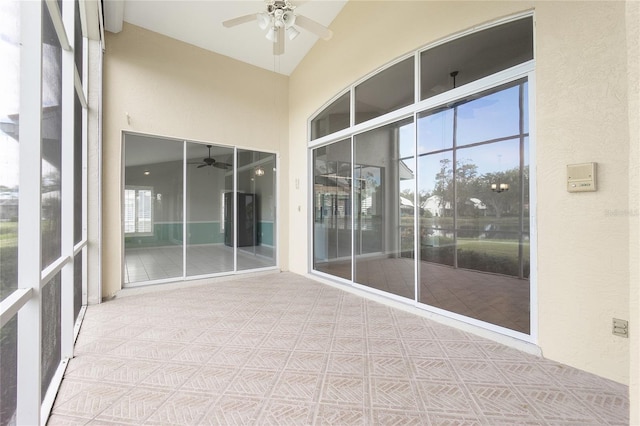 unfurnished sunroom with ceiling fan and vaulted ceiling