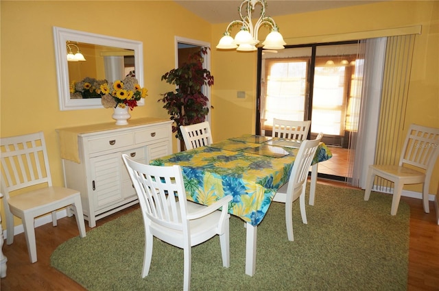 dining room with a notable chandelier, lofted ceiling, and hardwood / wood-style flooring