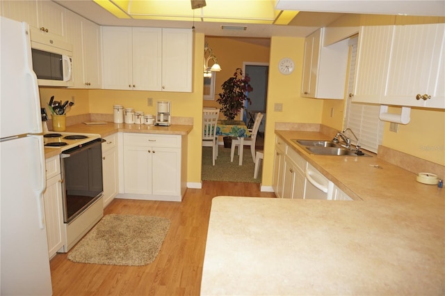 kitchen featuring white cabinetry, light wood-type flooring, white appliances, and sink