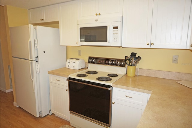 kitchen with light hardwood / wood-style floors, white cabinetry, and white appliances