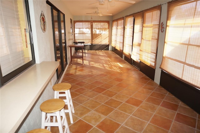 unfurnished sunroom with ceiling fan