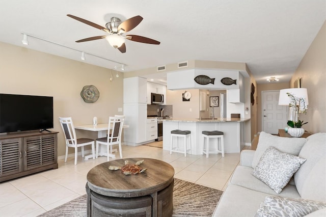 living room featuring ceiling fan, light tile patterned floors, and track lighting