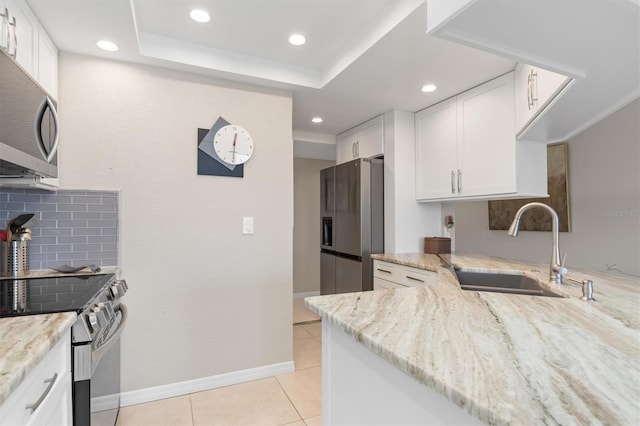 kitchen featuring sink, decorative backsplash, appliances with stainless steel finishes, light stone counters, and white cabinetry