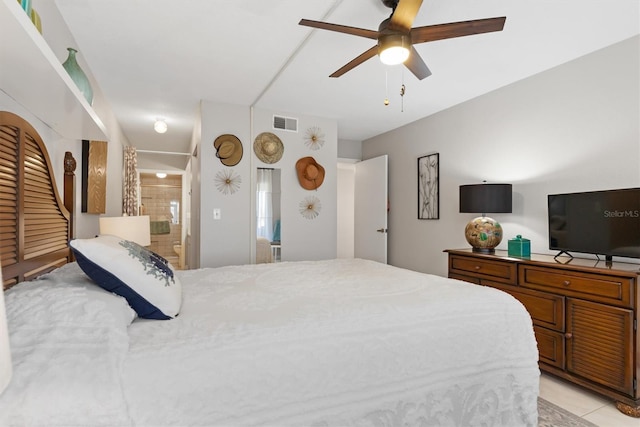 tiled bedroom with ensuite bath and ceiling fan