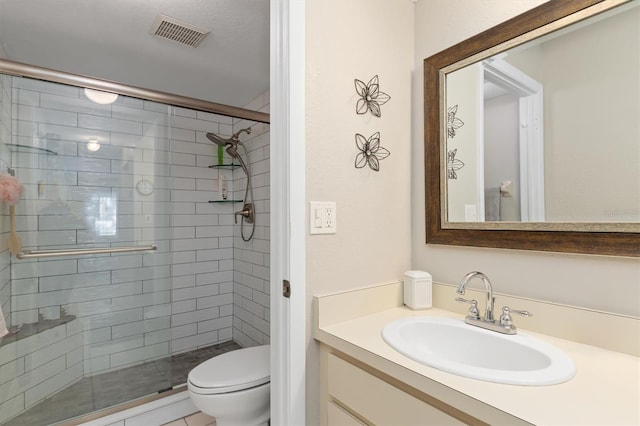 bathroom with vanity, toilet, and a shower with door