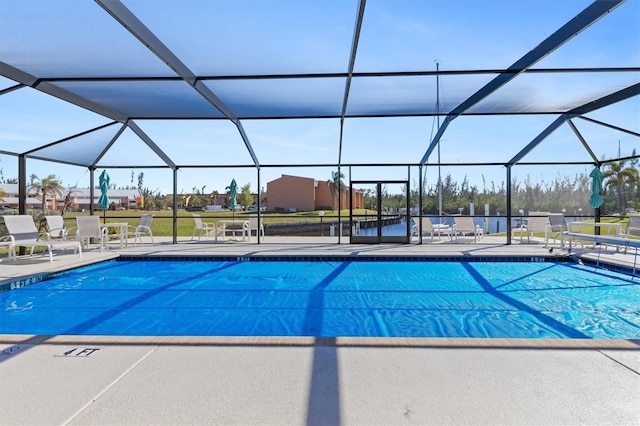 view of swimming pool featuring glass enclosure and a patio