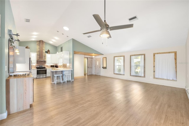 living room with light wood-type flooring, high vaulted ceiling, and ceiling fan